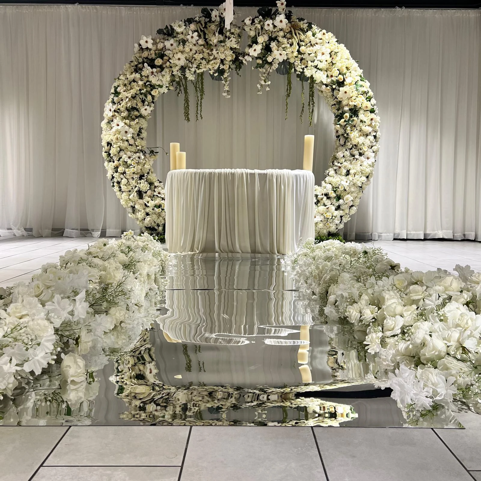 Elegant ballroom setup with white draping and crystal chandeliers for corporate event
