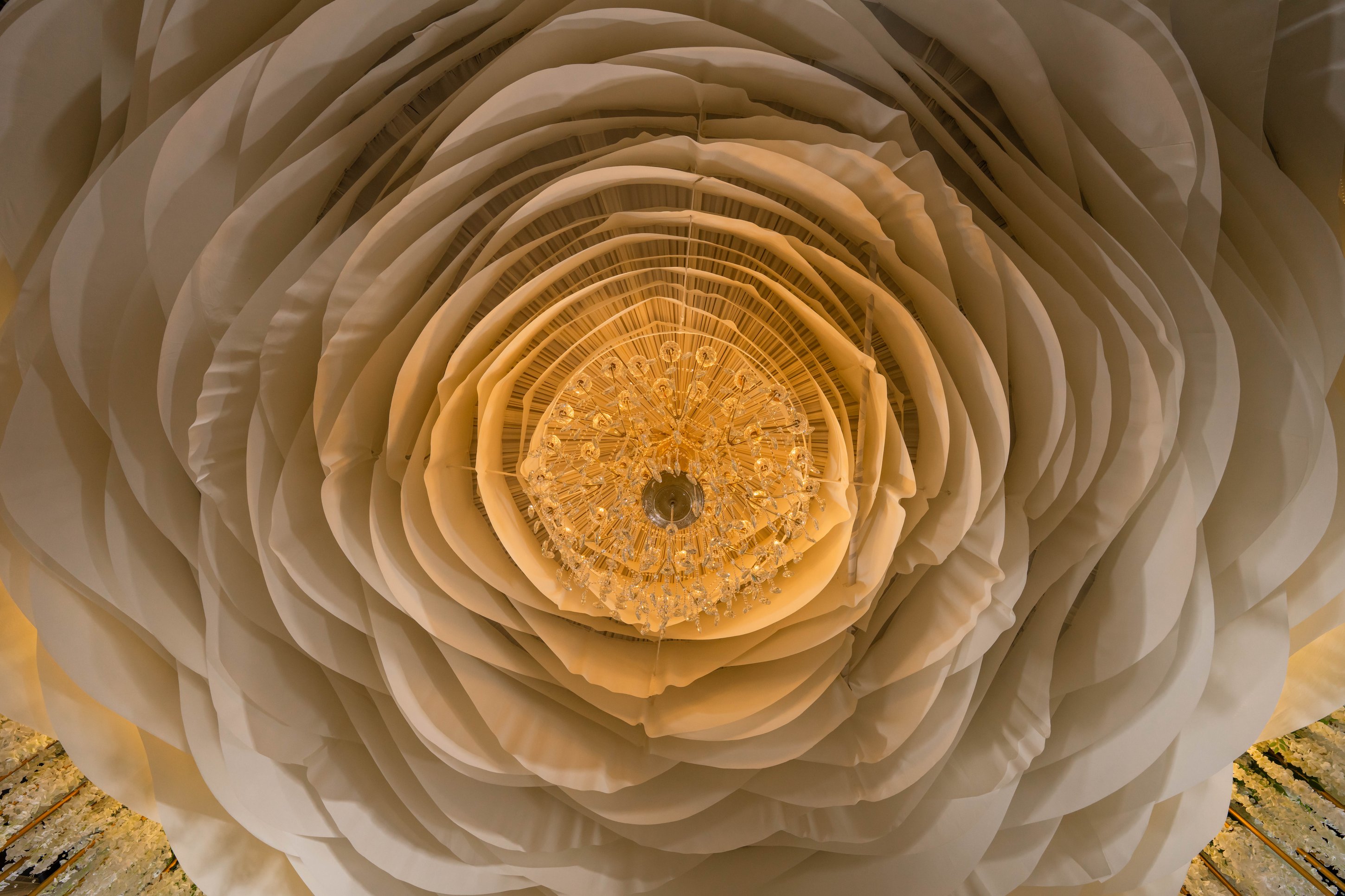 Ornate gold chandelier with warm lighting inside La Bella Luna Venue event space